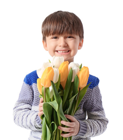 Cute little boy with spring flowers on white background