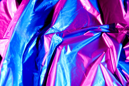 Crumpled foil in neon light as backgroundの写真素材