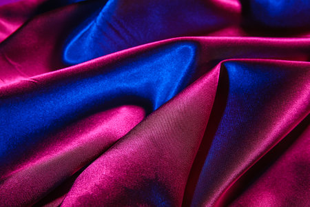 Crumpled silky fabric in neon light as backgroundの写真素材