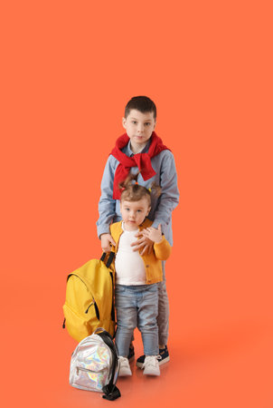 Cute little children with backpacks on color backgroundの写真素材