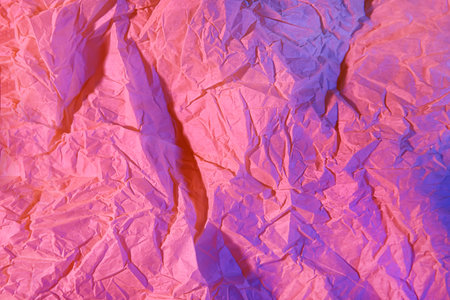 Crumpled paper in neon light as backgroundの写真素材