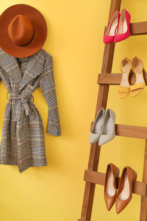 Wooden ladder with female shoes and clothes near color wall in hallの写真素材