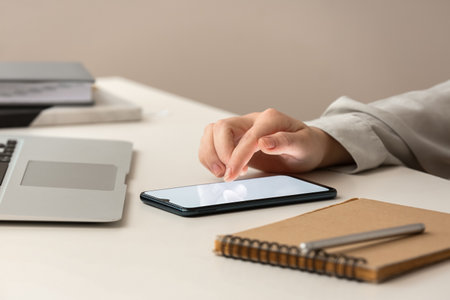 Woman using phone at table in office