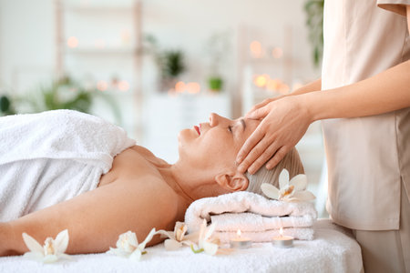 Mature woman receiving face massage in beauty salonの写真素材