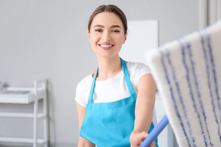 Young woman with floor mop in roomの写真素材