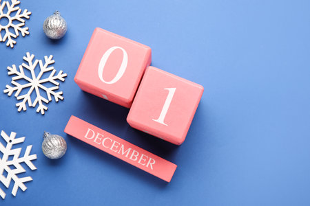 Calendar with date of December 1, snowflakes and Christmas balls on blue background