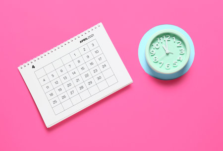 Flip paper calendar and alarm clock on color backgroundの写真素材