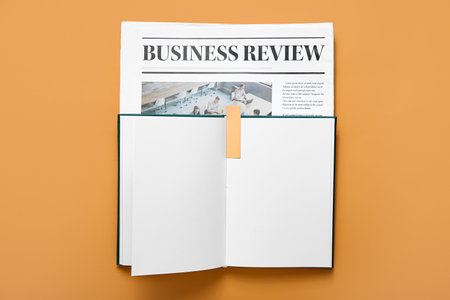 Book with bookmark and newspaper on color backgroundの写真素材