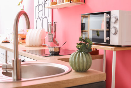 Modern microwave and electric stove in interior of stylish kitchenの写真素材