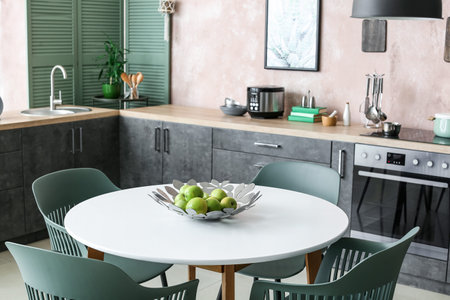 Dining table with apples in interior of stylish kitchen