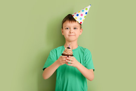 Cute little boy celebrating Birthday on color background