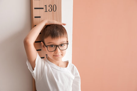 Little boy measuring height near color wallの写真素材