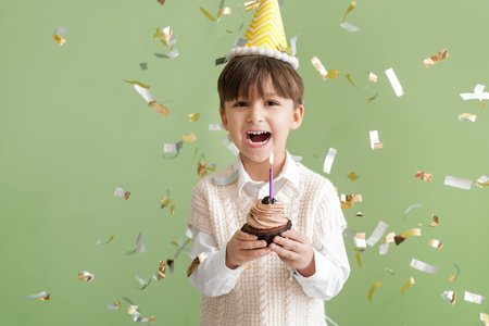 Cute little boy celebrating Birthday on color backgroundの写真素材