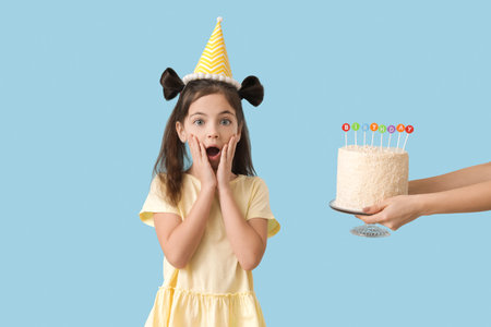 Cute little girl celebrating Birthday on color backgroundの写真素材