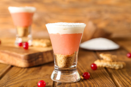 Shot of delicious pudding with coconut shavings and cranberry on wooden tableの写真素材