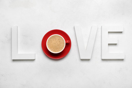 Word LOVE with cup of latte on white background. Valentine's Day celebrationの写真素材