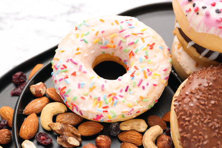 Plate with tasty donuts and nuts, closeupの写真素材