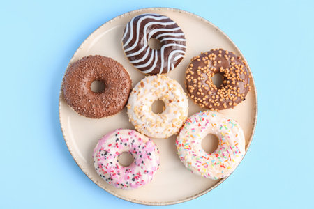 Plate of sweet donuts on color backgroundの写真素材