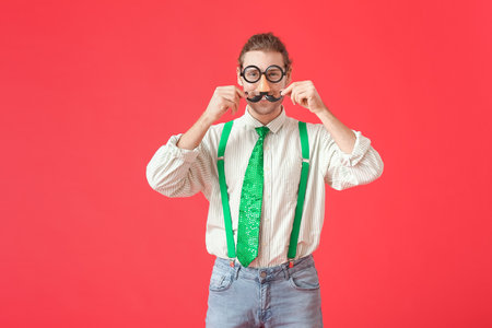 Young man in funny disguise on color background. April Fools Day celebrationの写真素材