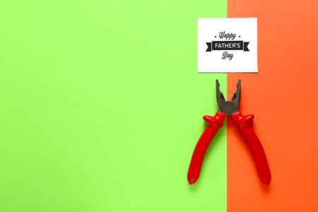 Composition for Father's Day with pliers and greeting card on color backgroundの写真素材