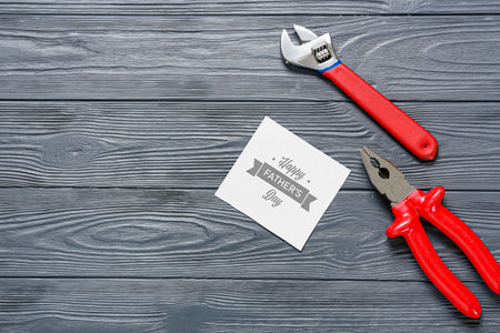 Composition for Father's Day with greeting card and tools on wooden backgroundの写真素材