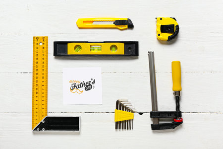 Composition for Father's Day with different tools on white wooden background