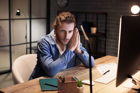Handsome man working at home late in the eveningの写真素材