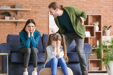 Crying little girl and her quarrelling parents at homeの写真素材