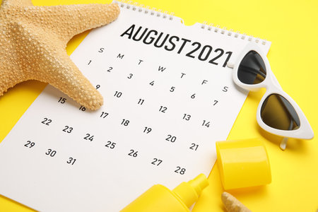 Calendar with beach accessories on color background, closeupの写真素材