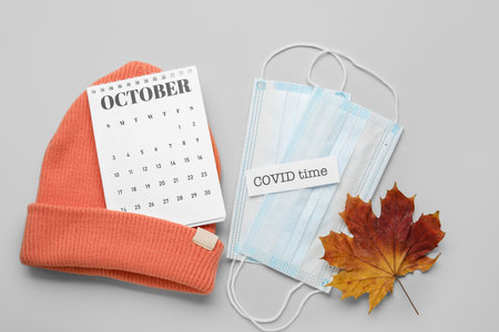 Calendar with hat and medical masks on light backgroundの写真素材