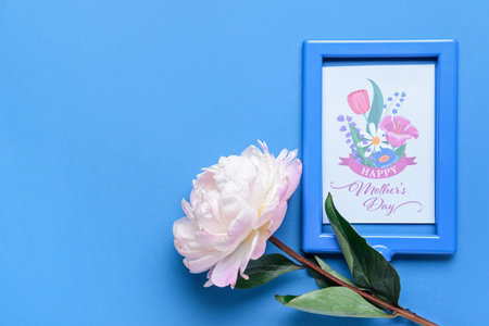 Beautiful flower and greeting card for Mother's Day on color background
