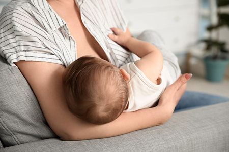 Young woman breastfeeding her baby at home, closeupの写真素材