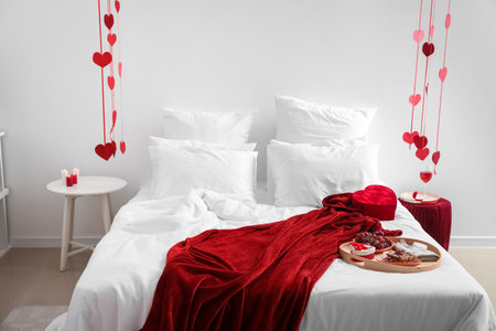 Interior of light bedroom decorated for Valentine's Day with breakfast and heartsの写真素材