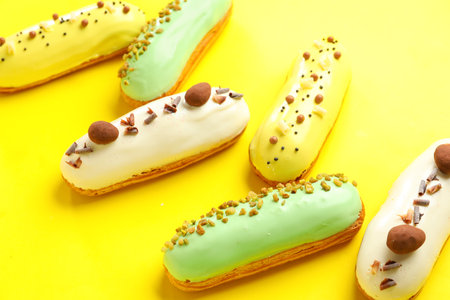 Various glazed eclairs on yellow backgroundの写真素材