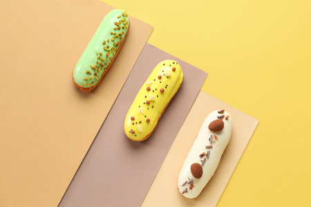 Various glazed eclairs on yellow background