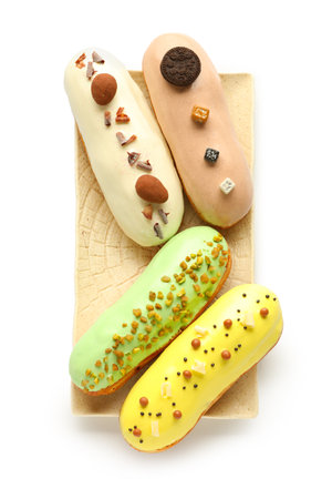 Plate with various glazed eclairs isolated on white background