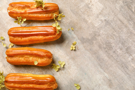 Sweet eclairs and dried flowers on grunge background