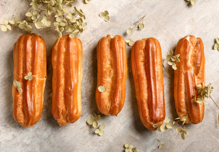 Sweet eclairs and dried flowers on grunge background