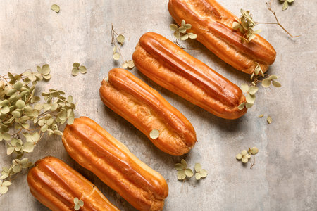Sweet eclairs and dried flowers on grunge background