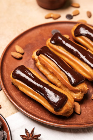 Plate with tasty chocolate eclairs on color background, closeup