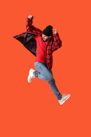 Jumping young man on color backgroundの写真素材