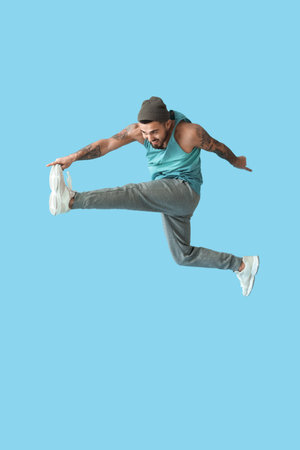 Jumping young man on color background