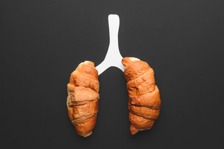 Human lungs made of croissants on dark background