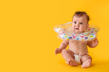 Cute baby with inflatable ring on color backgroundの写真素材