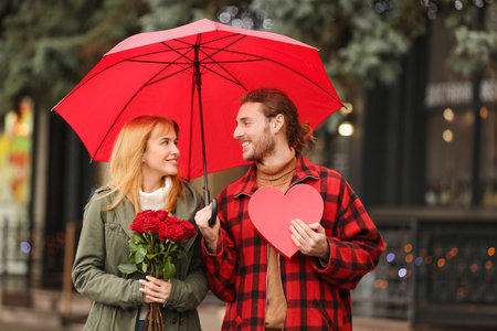 Happy young couple walking in city on Valentine's Dayの写真素材