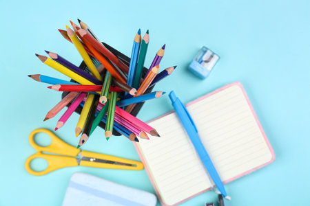 Holder with stationery and open notebook on blue background