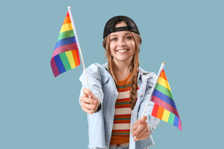 Beautiful young woman with LGBT flags on blue backgroundの写真素材