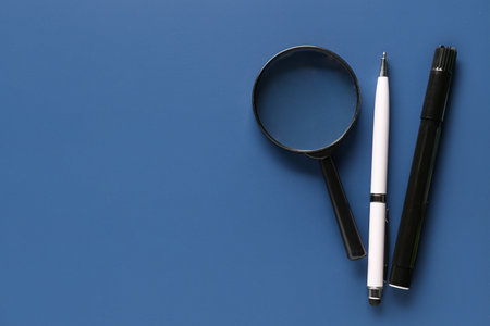 Pen, marker and magnifier on color background