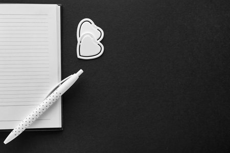 Notebook, pen and paper clips on dark backgroundの写真素材