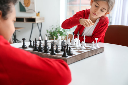 Cute children playing chess at homeの写真素材